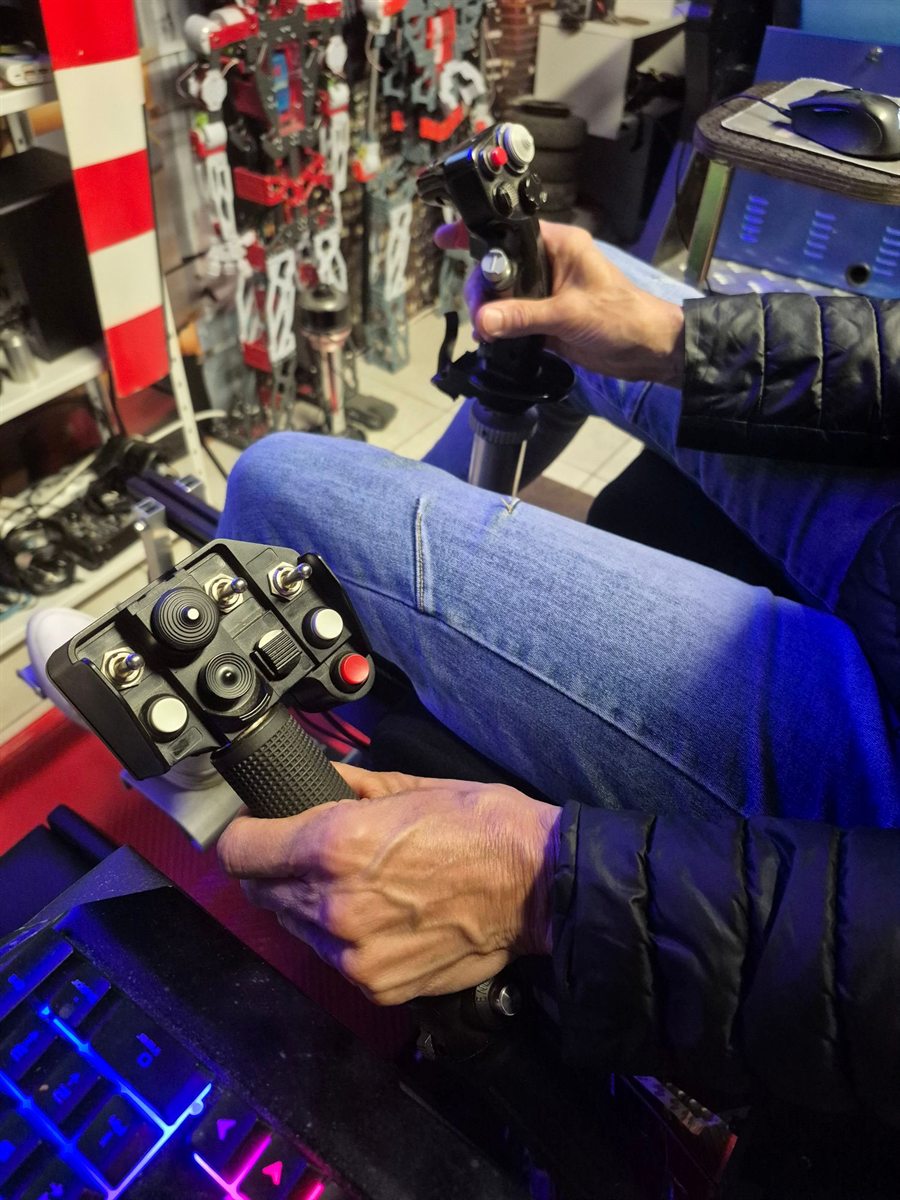 Pilote aux commandes du simulateur d’hélicoptère : pas collectif à gauche, cyclique à droite